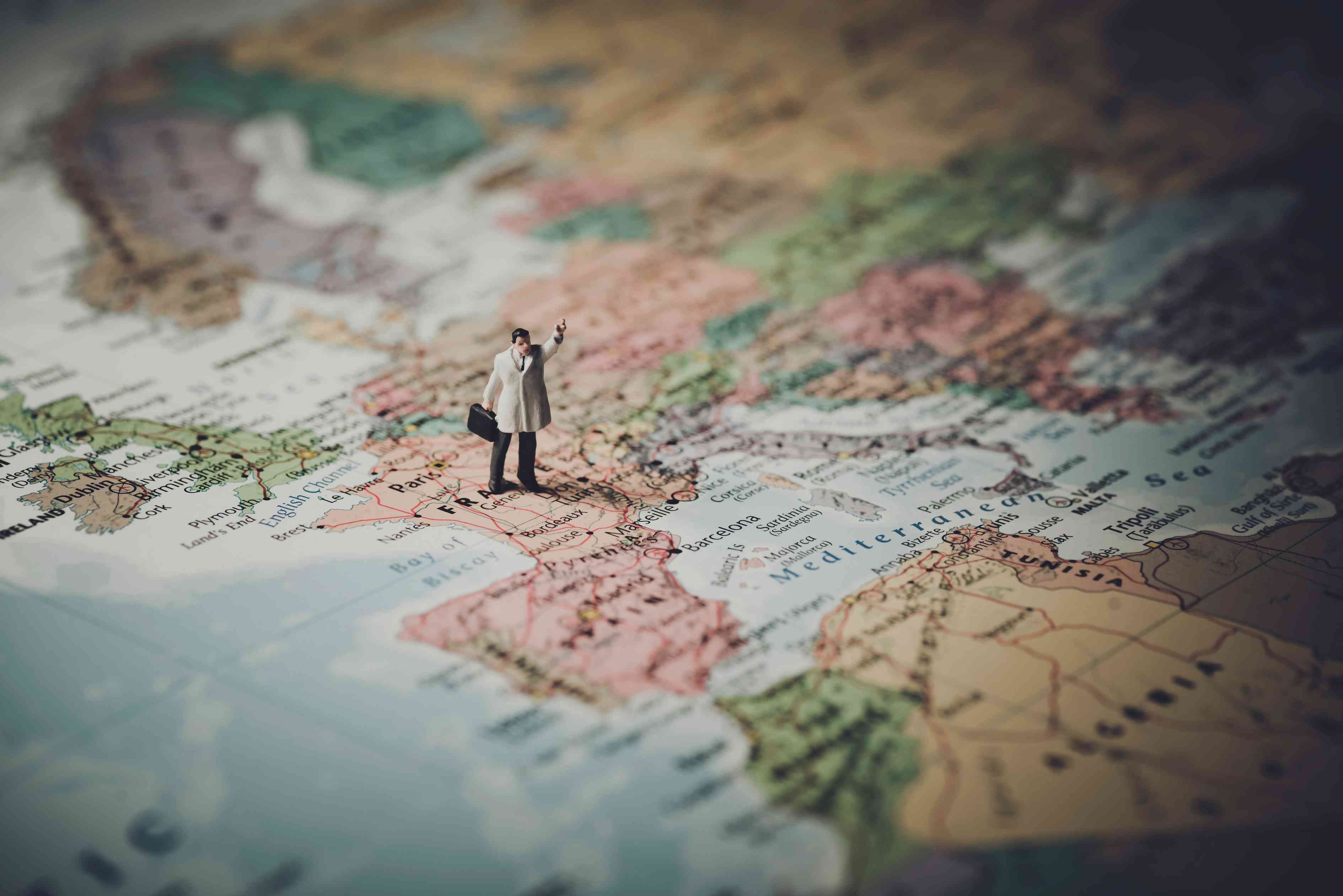 Small toy man standing on map showing different territories for email segmentation