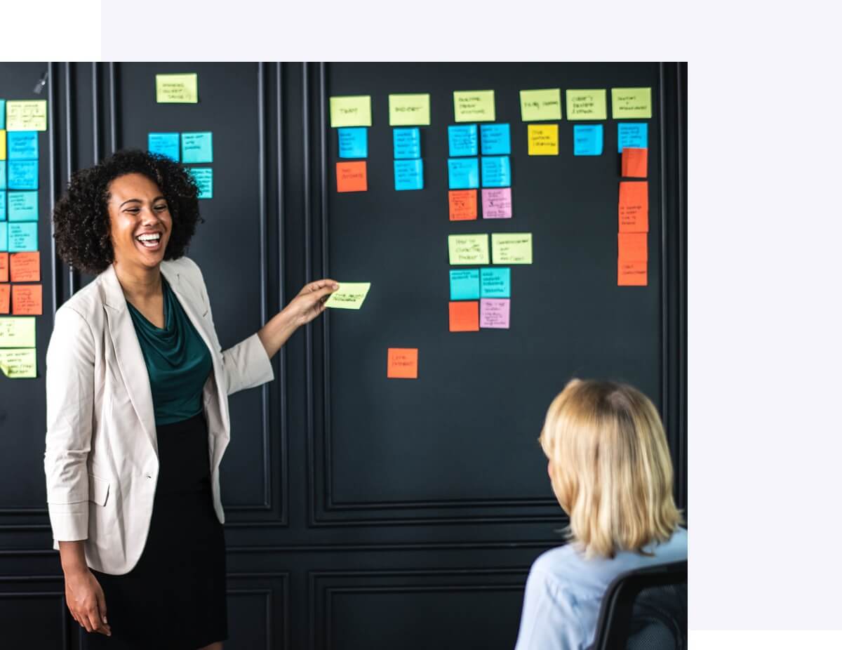Woman pasting sticky notes on app development workboard