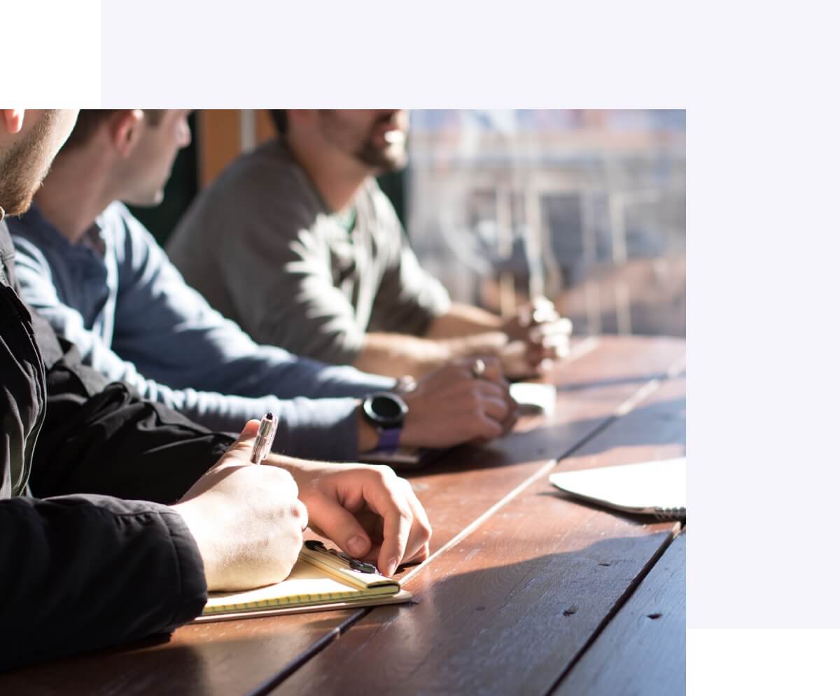 People writing on notepads and discussing content marketing
