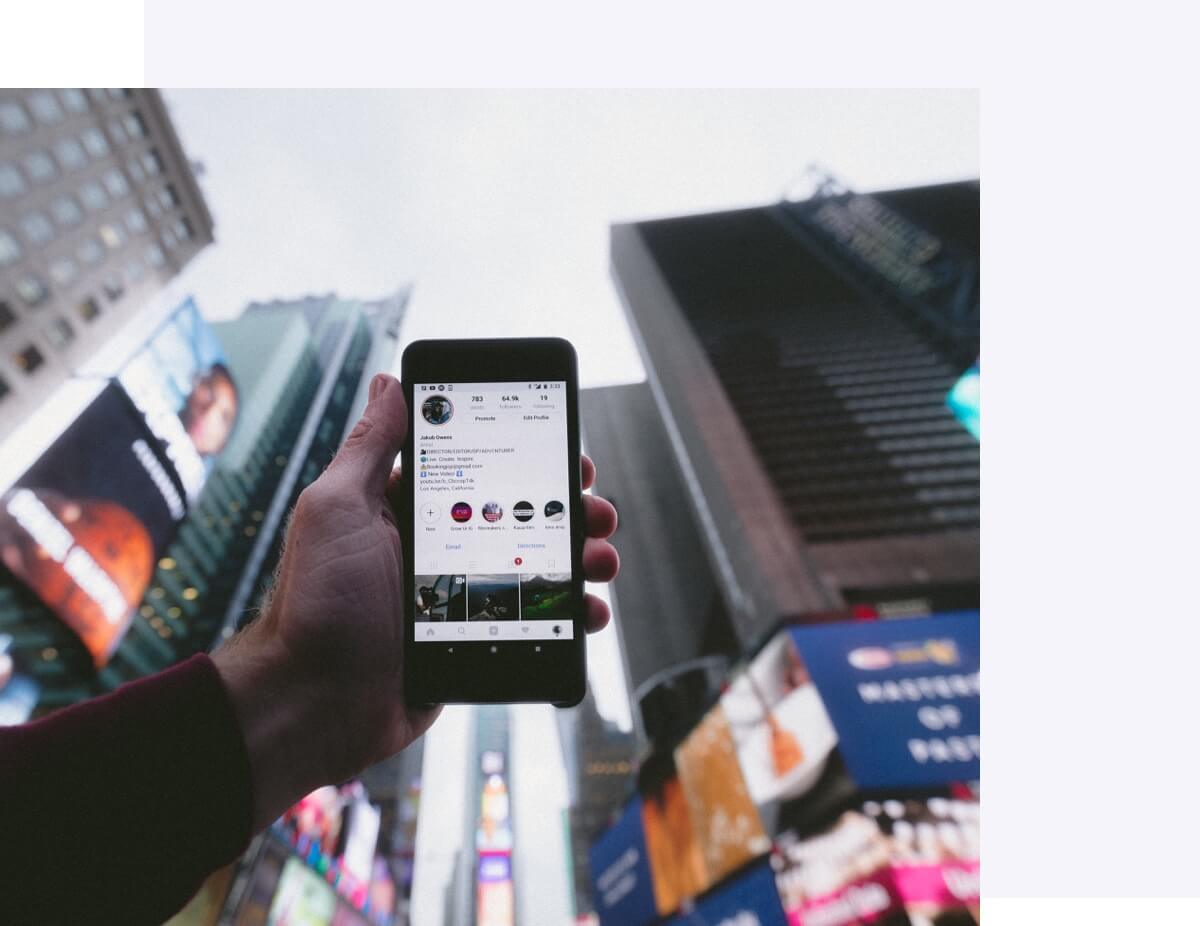 Holding a phone up using Instagram in Times Square