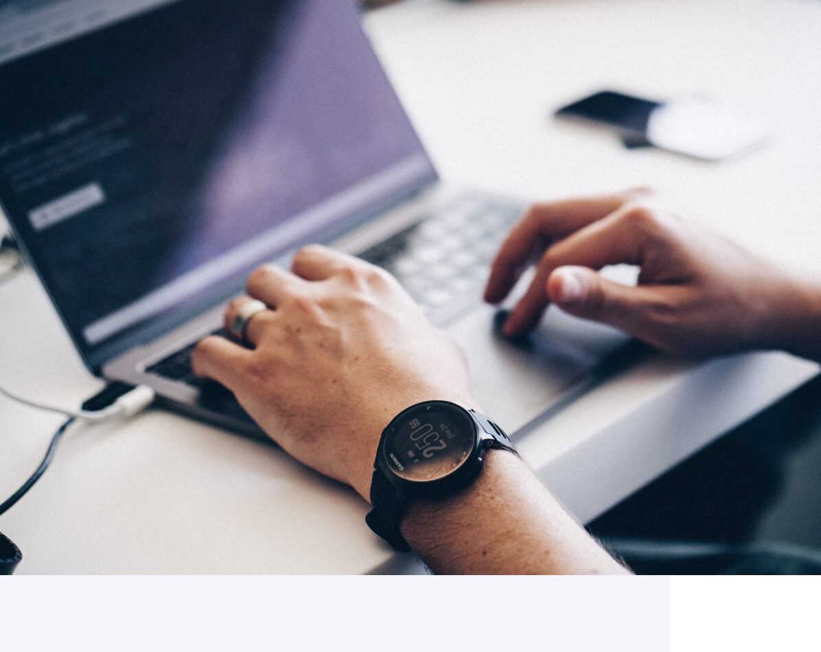 Hands typing on keyboard of laptop computer undertaking Shopify website support